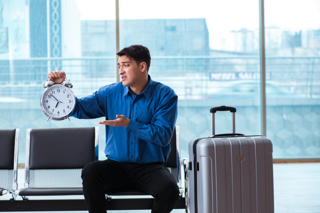 man in airport stressed out about time schedule
